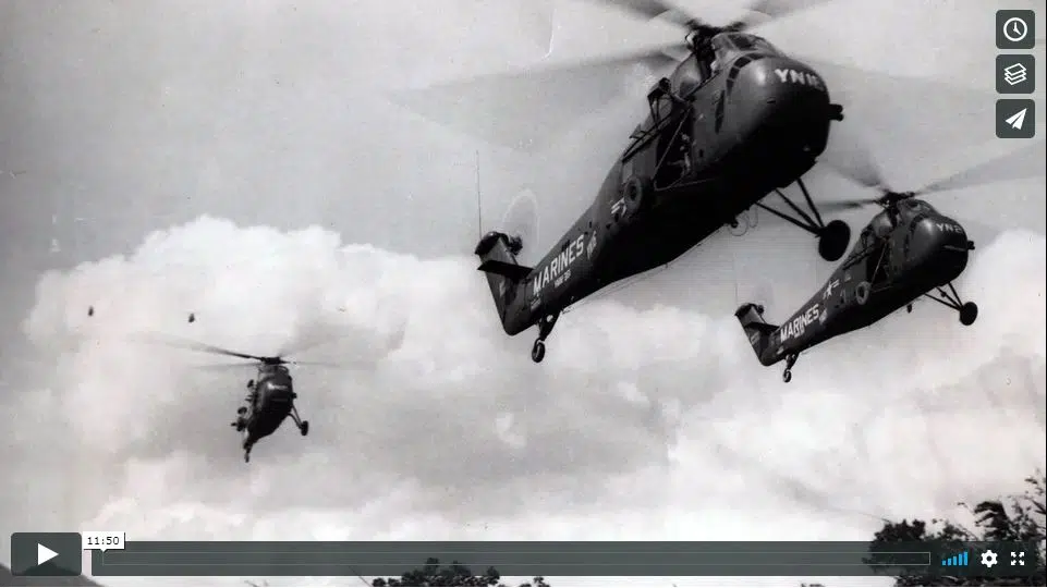 Three Sikorsky H-34 helicopters, marked with "MARINES" and squadron codes like "YN," fly in formation through a cloudy sky.